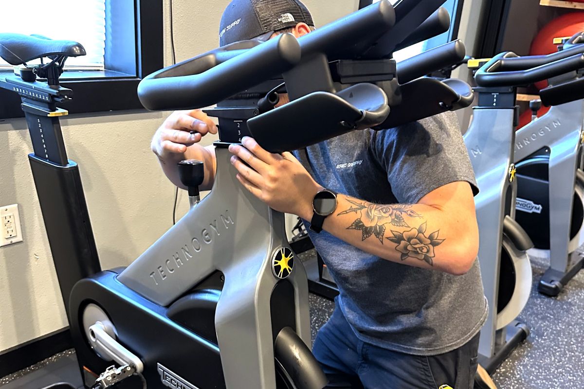 One of Express Gym Supply's professional technicians assembling a TechnoGym exercise bike