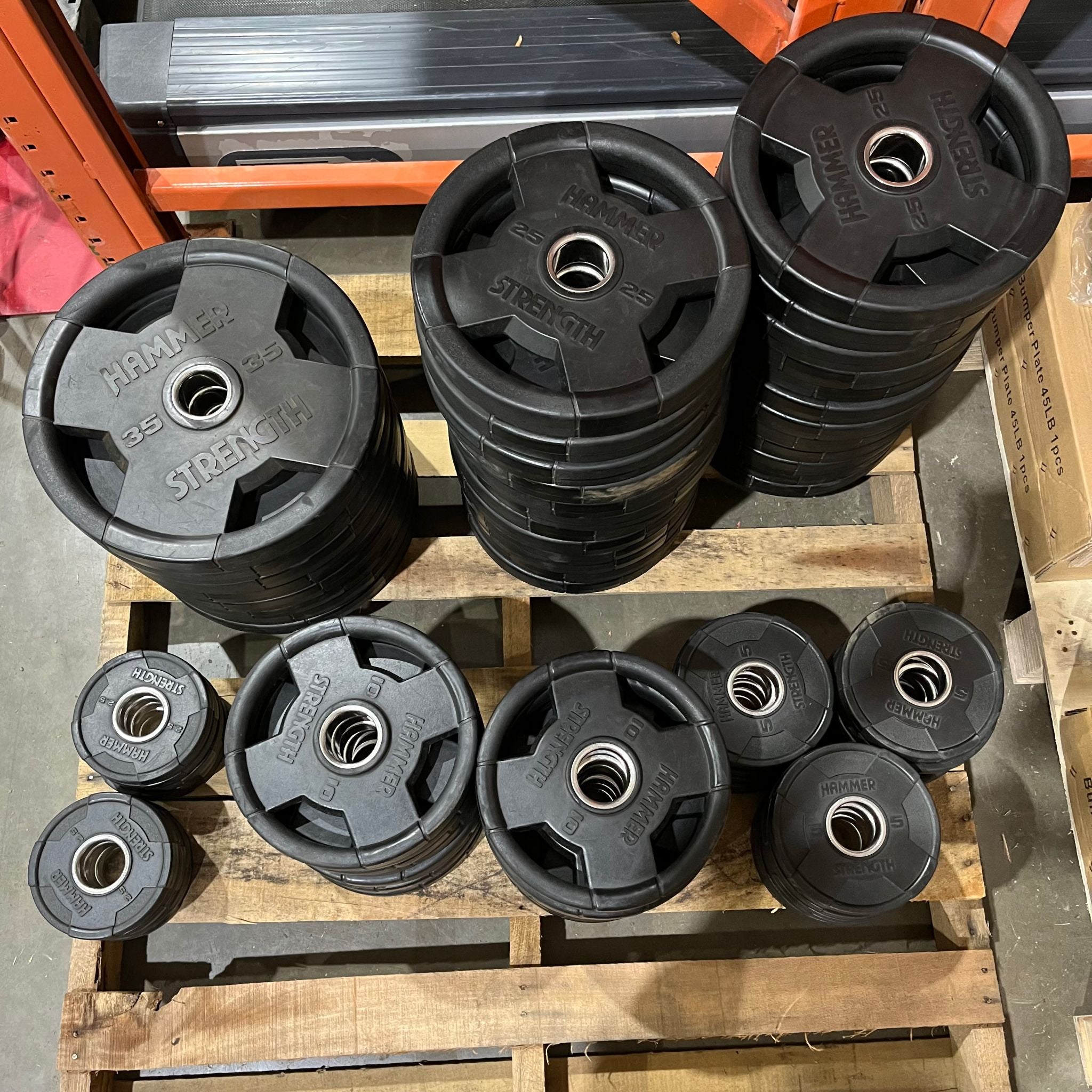 Hammer Strength Assorted Weight Plates on a pallet in Express Gym Supply's warehouse